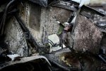 A severely burnt hand of a passenger sticks out of the charred MH17 fuselage at the plane's cras.jpg